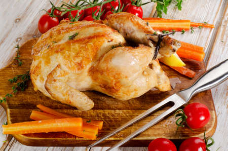 whole roasted chicken with vegetables on  cutting board. Selective focusの写真素材