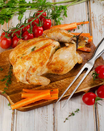 whole roasted chicken with vegetables on a cutting board. Selective focusの写真素材