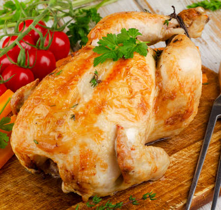 Roasted chicken with vegetables on   wooden board. Selective focusの写真素材