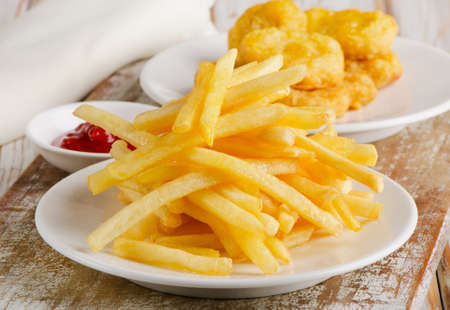 French fries and chicken nuggets on  wooden board. Selective focusの写真素材