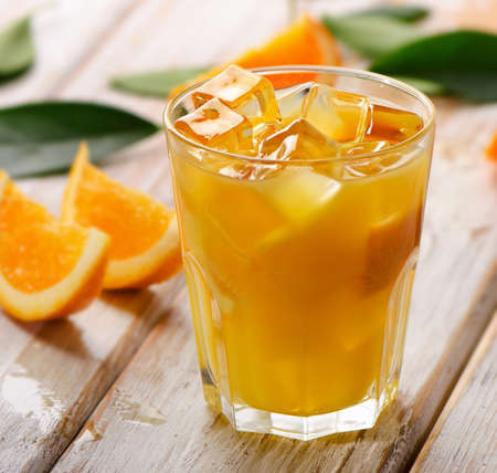 Orange juice in glass with  fresh fruits on a wooden background. Selective focusの写真素材