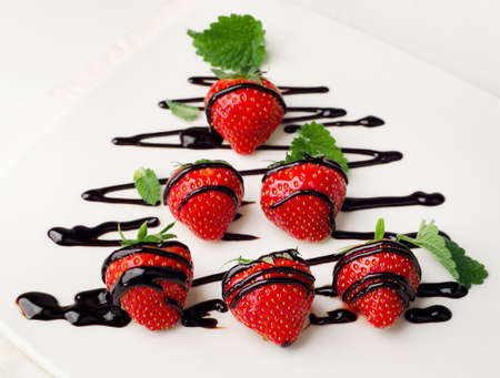 Fresh strawberries dipped in chocolate sauce on   plate. Selective focusの写真素材