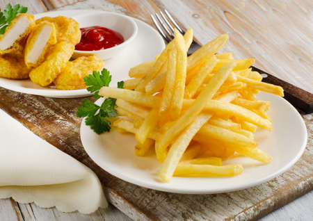 fries and chicken nuggets on a  wooden table. Selective focusの写真素材