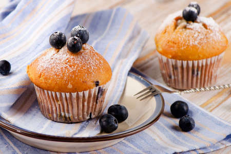 Muffins with fresh blueberries on wooden table. Selective focusの写真素材