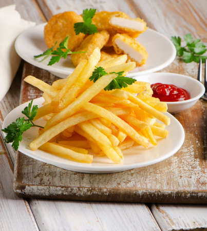 French fries and chicken nuggets on  a wooden table. Selective focusの写真素材