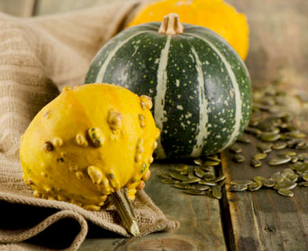 Yellow and green Pumpkins and seeds  on a wooden background. Selective focusの写真素材