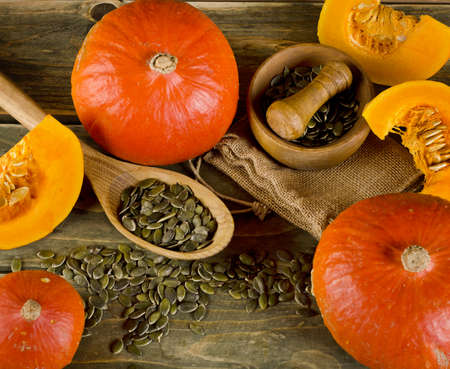 Orange pumpkins and seeds  on  wooden background. Selective focusの写真素材