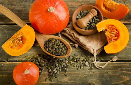 Orange pumpkins and seeds  on a wooden table. Selective focusの写真素材