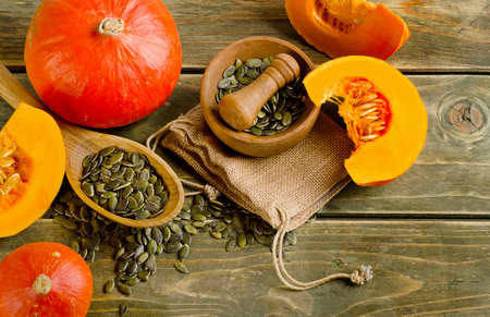 Pumpkins and seeds  on wooden background. Selective focusの写真素材