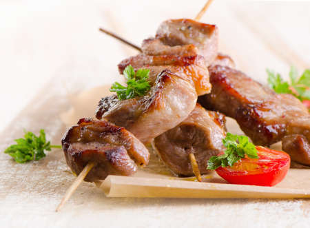 Pork kebabs served with vegetables on wooden table. Selective focusの写真素材