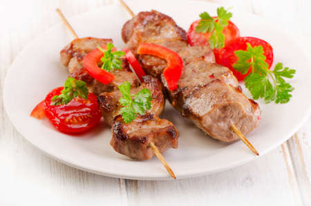 Pork kebabs served with vegetables on  white plate. Selective focusの写真素材