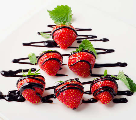 Strawberries  in chocolate sauce on a white plate. Selective focusの写真素材