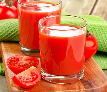 Tomato juice and ripe tomatoes  on  a wooden background. Selective focusの写真素材