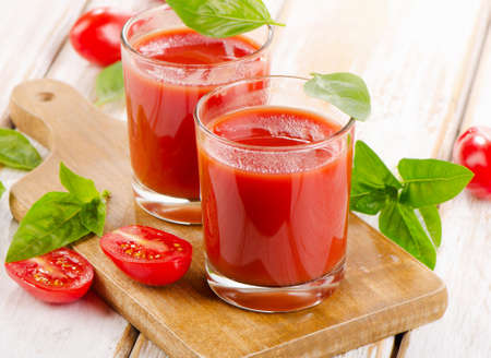 Tomato juice and fresh tomatoes  on  wooden background. Selective focusの写真素材