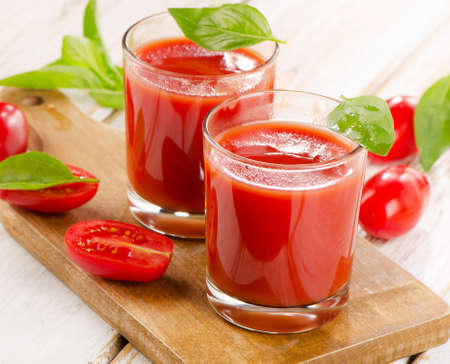 Tomato juice and fresh tomatoes  on a wooden background. Selective focusの写真素材
