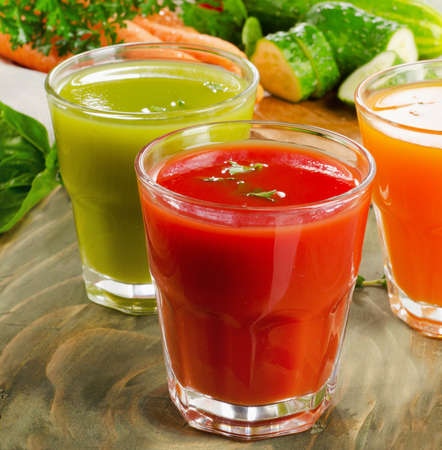 Fresh vegetable  juices on a wooden table. Selective focusの写真素材