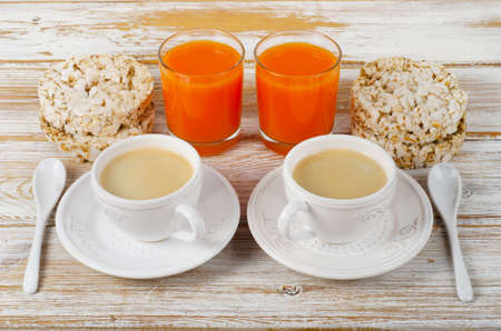 Breakfast with  two coffee cup, orange juice  on a white wood table.の写真素材