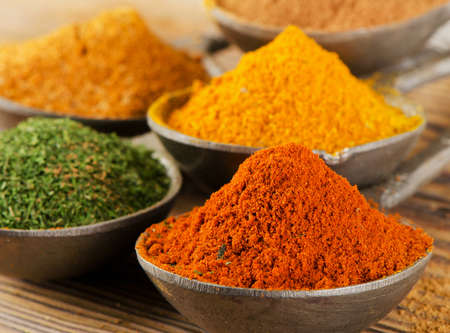 Spices on spoons on a wooden backgroundの写真素材