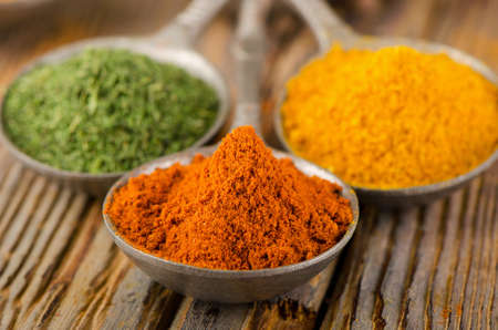 Ground spices on spoons on a wooden backgroundの写真素材