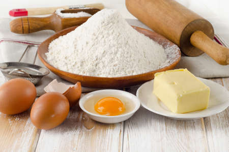 Baking ingredients - eggs, flour, sugar, butter on  wooden tableの写真素材