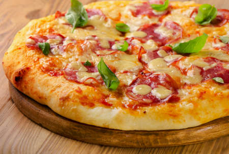 Salami pizza on a wooden  board. Selective focusの写真素材