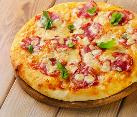 Fresh homemade salami pizza on  wooden  board. Selective focusの写真素材