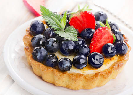 Fresh blueberries tart on a white plate.の写真素材