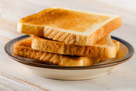 Slices toast bread on a wooden table. Selective focus