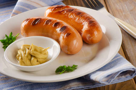 Two grilled sausages with mustard sauce. Selective focusの写真素材