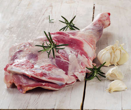 Raw lamb leg on  wooden cutting board. Selective focusの写真素材