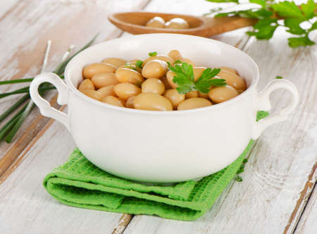 Beans  with fresh herbs  on a  wooden table . Selective focusの写真素材