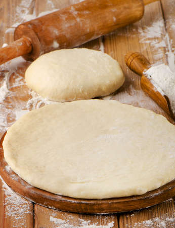 pizza dough on  a wooden table .の写真素材