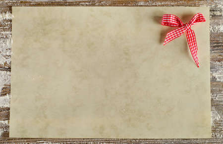 Empty paper with  bow on a old wooden background.