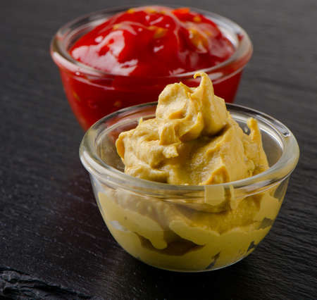 tomato and mustard sauce on  black background. Selective focus
