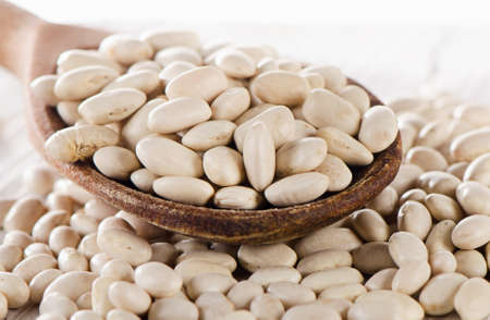 White beans in a wooden spoon. Selective focus