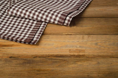 Brown checkered Tablecloth textile on a wooden background.の写真素材
