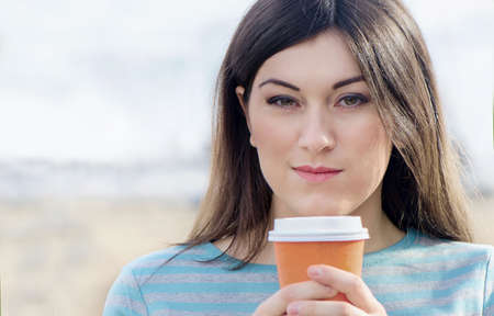 Woman with Coffee in To-Go Cup outdoors. Selective focusの写真素材