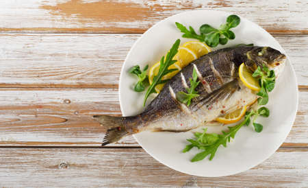 Fried sea bream on plate with  a lemon.  Healthy food.