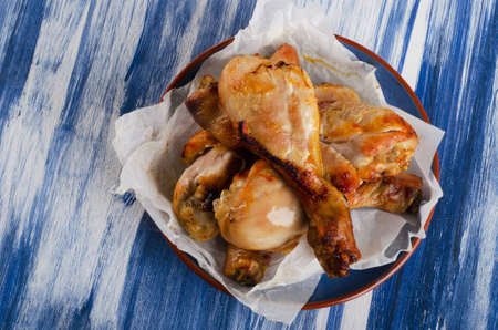 Roasted chicken legs on  blue plate. Top viewの写真素材