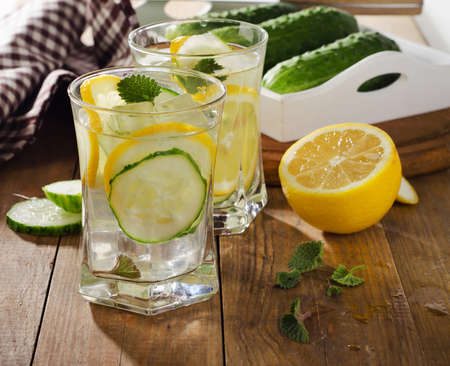 Fresh water with lemon, mint  and cucumber  on  wooden background. Selective focusの写真素材