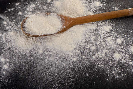 Flour in a old  wooden spoon. Selective focusの写真素材