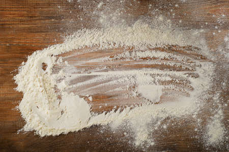 White flour on a worn wooden  desk.の写真素材