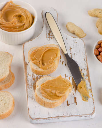 Toast with Peanut butter  and peanuts on wooden board. Top viewの写真素材