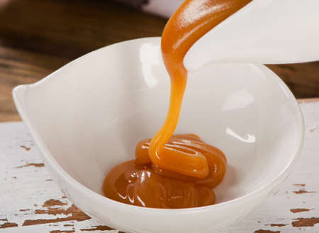 Caramel sauce pouring in  a bowl. Selective focusの写真素材