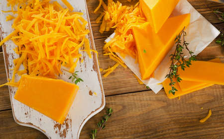Cheddar Cheese on white wooden cutting Board. Top viewの写真素材