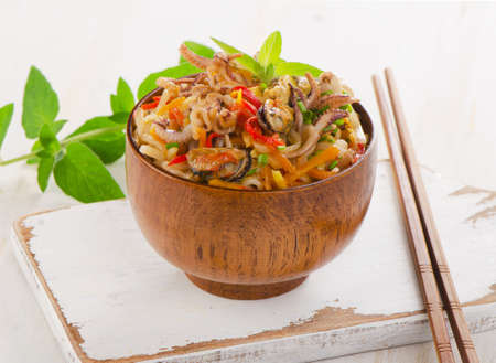 Delicious rice noodles with seafood closeup in a wooden bowl. Selective focusの写真素材
