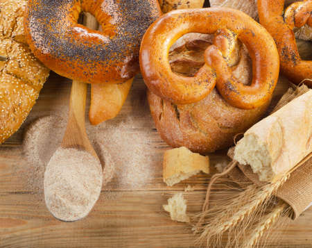Fresh bread and flour on  a rustic wooden background. Top viewの写真素材