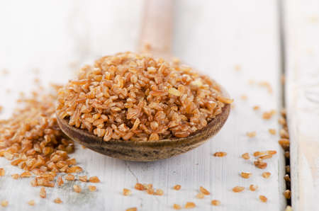 Bulgur in  a old wooden spoon. Selective focusの写真素材