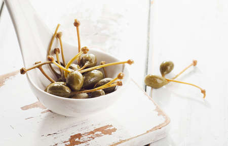 Pickled capers on a white spoon. Selective focusの写真素材