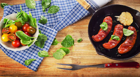 Fried sausages on a pan on  wooden table. Selective focusの写真素材